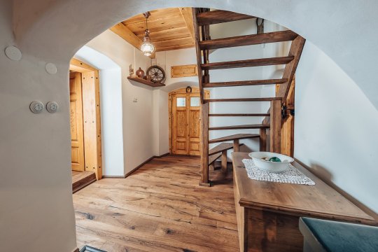 Předsíň s vinárnou, vstupem do sklepa a schody do 1. patra